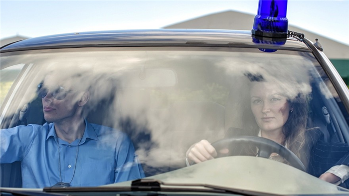 Two young detectives driving to crime scene. Windscreen view