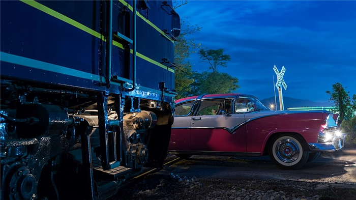 Vintage car racing across railroad crossing