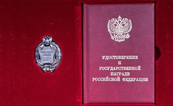 Во время награждения заслуженному артисту прикрепляют почетный знак на одежду и вручают удостоверение